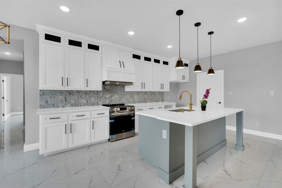 Kitchen with white cabinets, an island with sink, tasteful backsplash, sink, and stainless steel stove