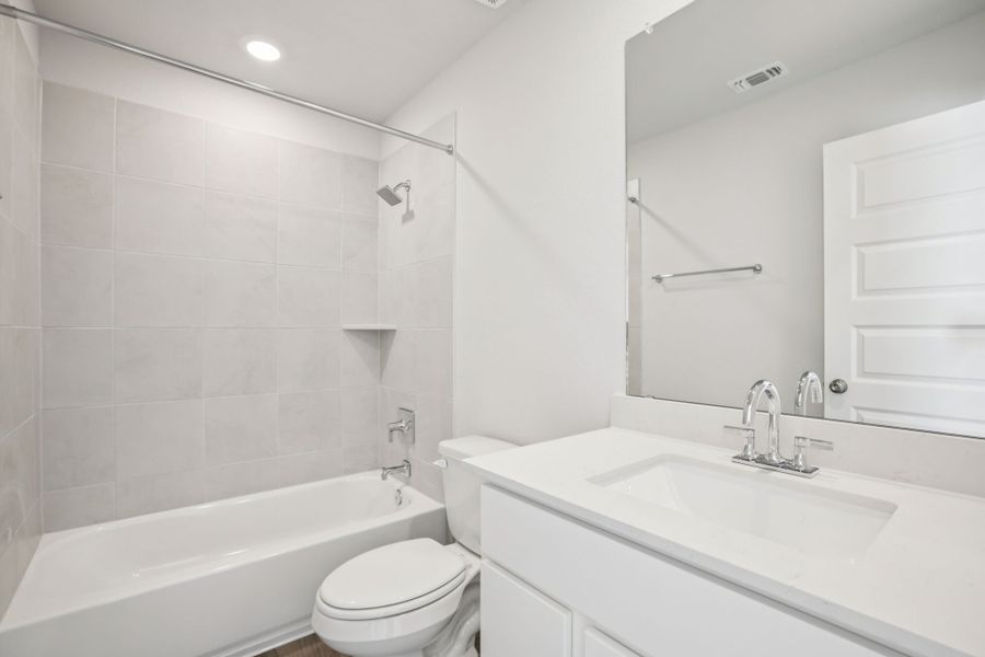 A bathroom with a tub sink and toilet.