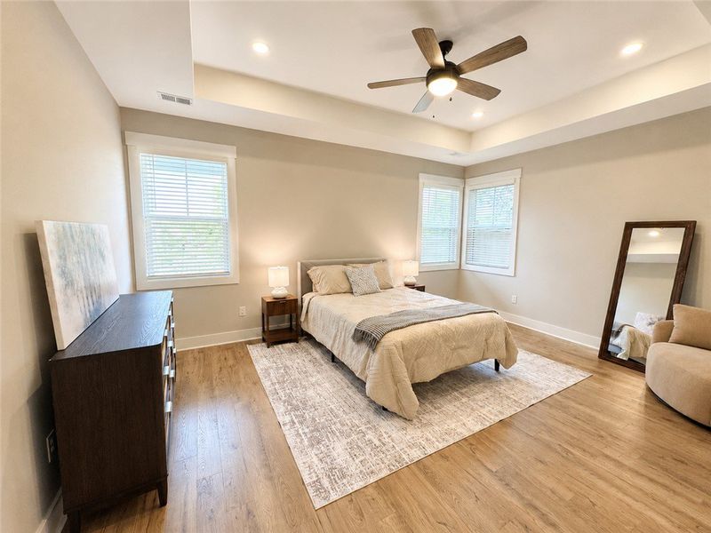 A tranquil primary bedroom with warm flooring and A tranquil primary bedroom with warm flooring and