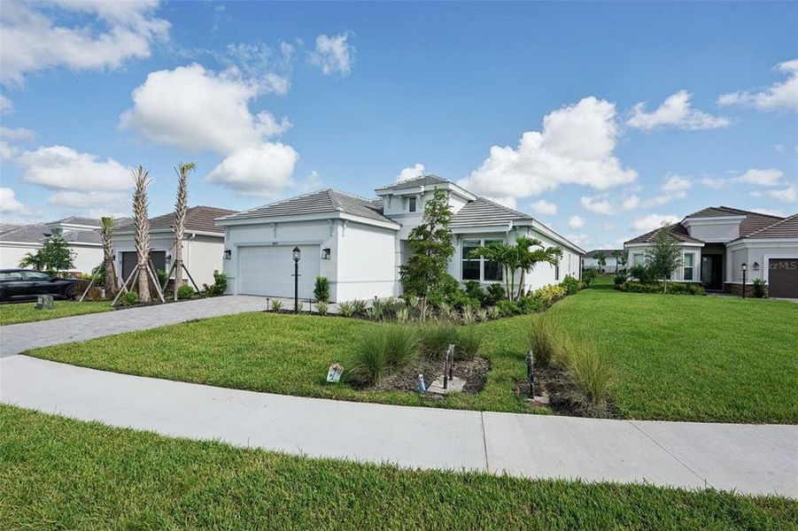 Front exterior of a new home in Esplanade at Azario Lakewood Ranch, Bradenton, FL, highlighting curb appeal (Image 25).