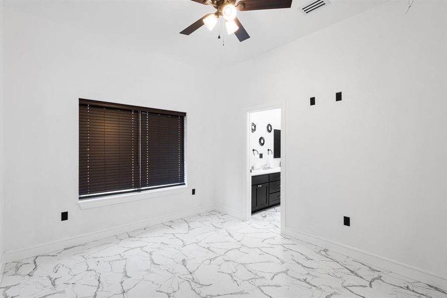 Spare room featuring light marble finish floors and ceiling fan