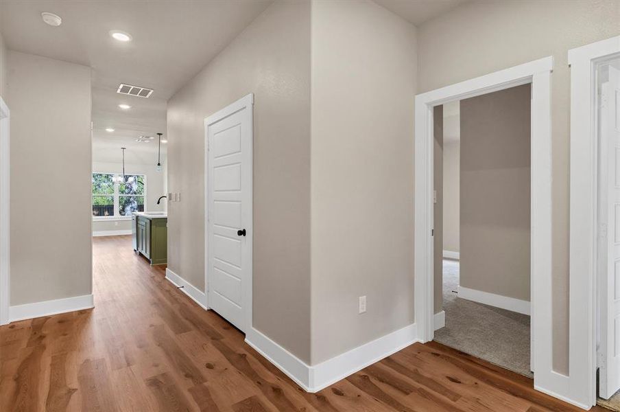 Hallway with dark wood-style flooring and recessed lighting Hallway with dark wood-style flooring and recessed lighting