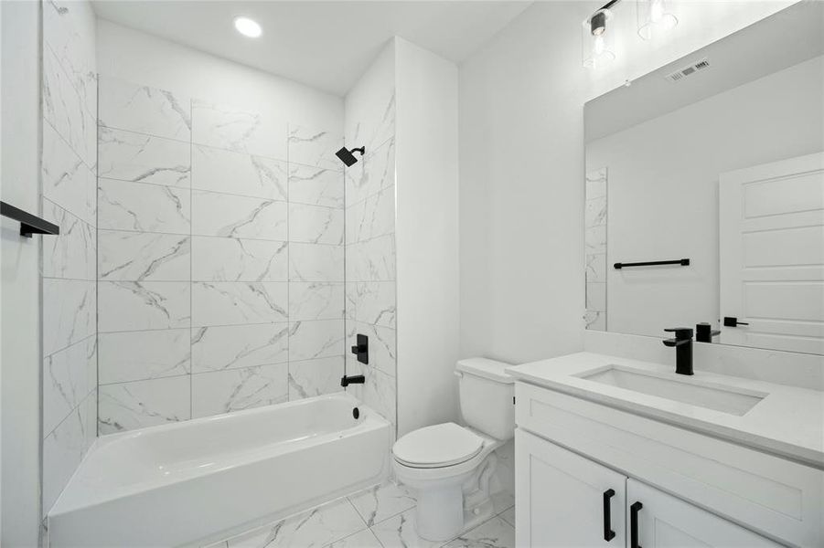 Bathroom with vanity, marble look tile flooring, shower / bathtub combination, and recessed lighting