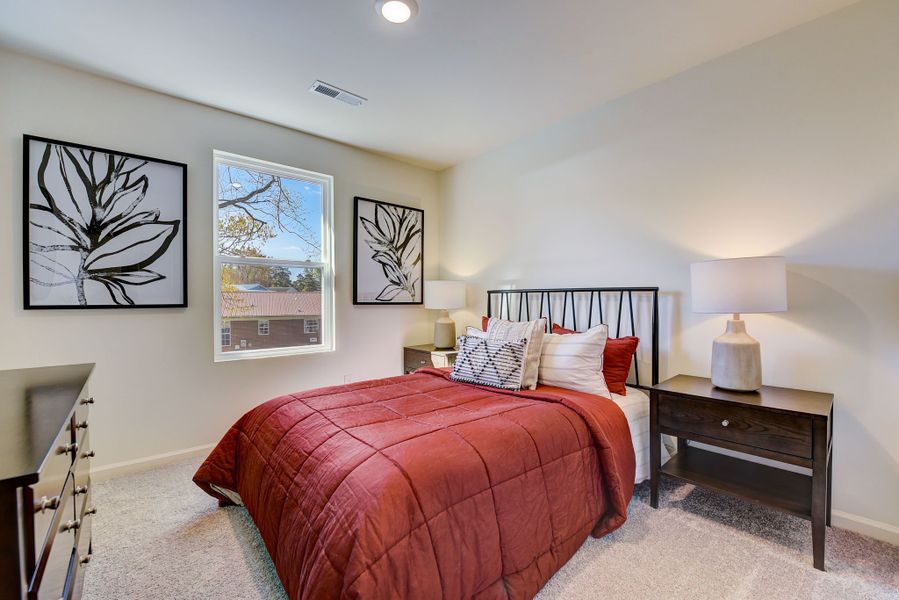 A bedroom with a bed and lamps.