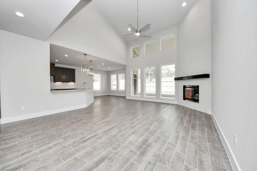 Family room flooded with natural light through the expansive windows.  The premium tile flooring adds a touch of luxury to the space, creating the perfect setting for relaxing moments and cherished gatherings with loved ones.