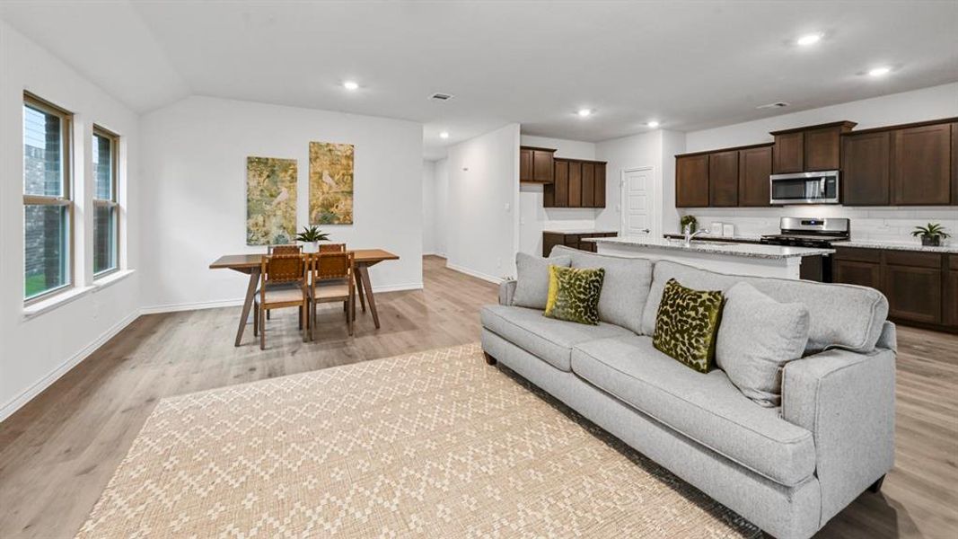 Living area with light wood finished floors and recessed lighting