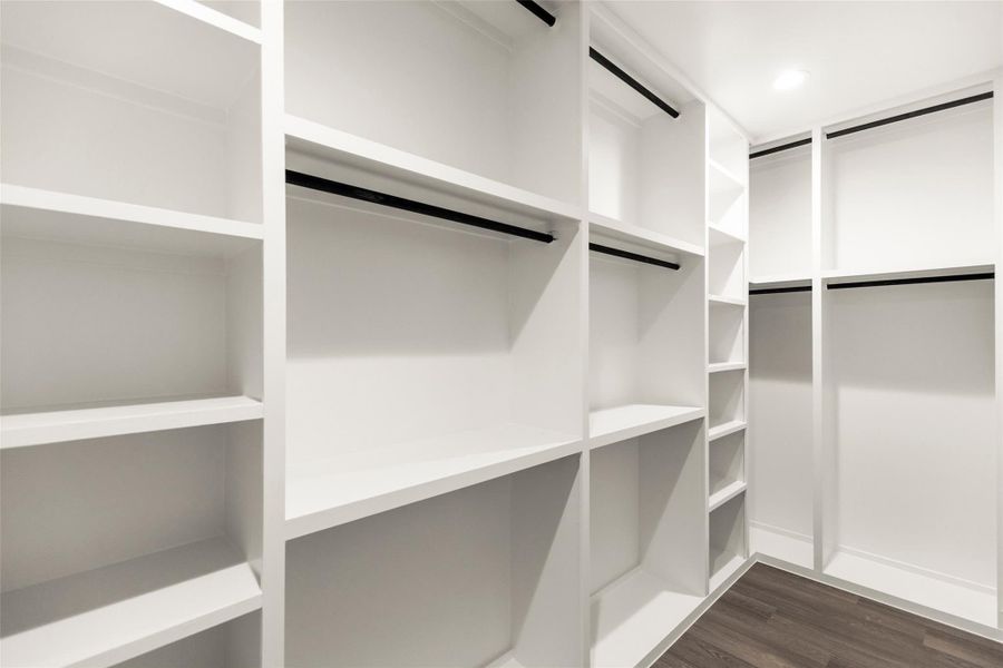 Expansive walk-in closet with custom built-in shelving and ample storage space. Expansive walk-in closet with custom built-in shelving and ample storage space.