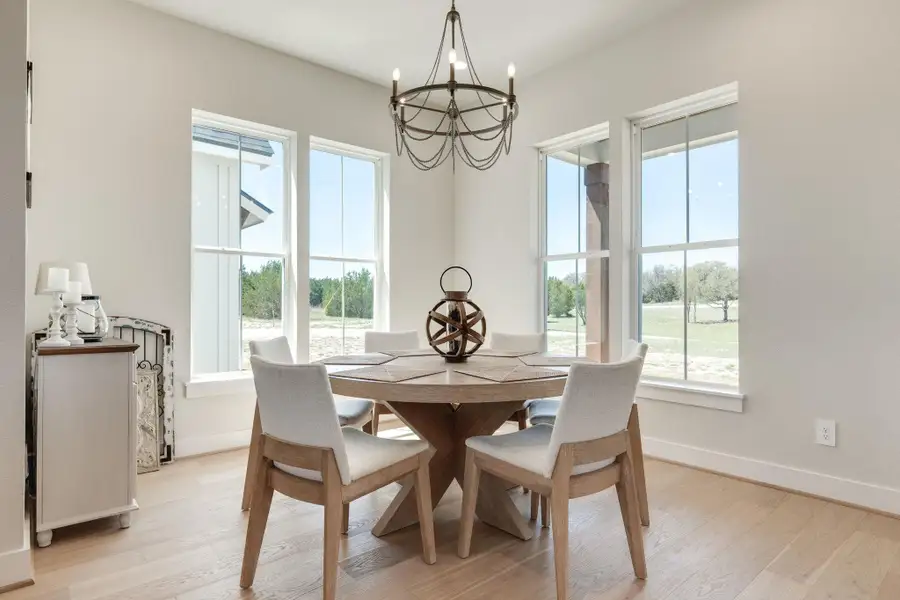Dining space with suspended lighting and light wood-type flooring