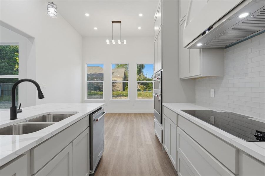 Modern kitchen featuring light cabinetry, stainless steel appliances, and white countertops
