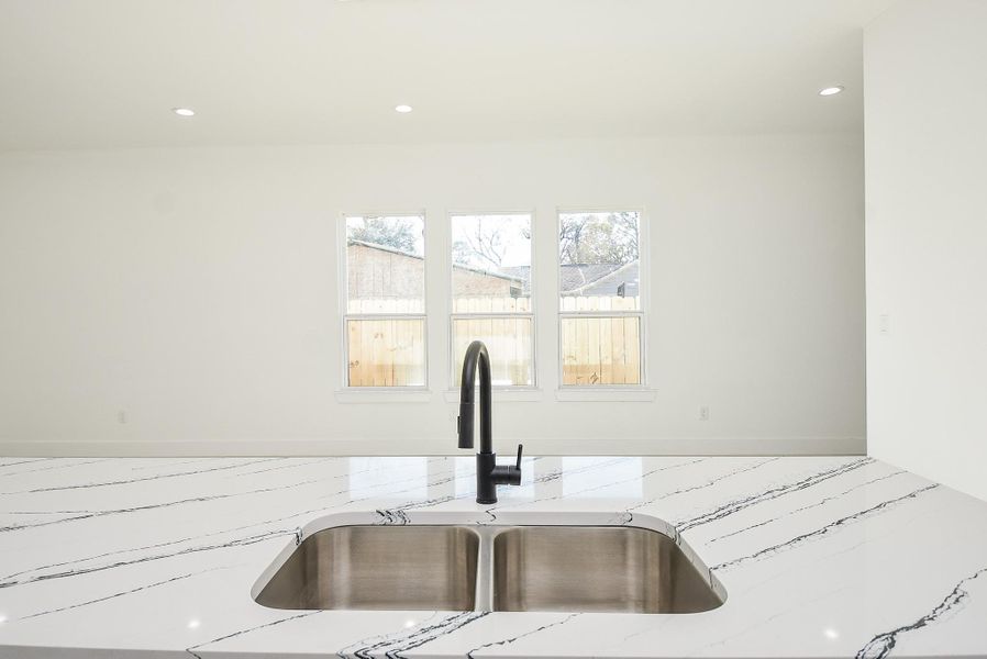This stunning kitchen island features a sleek quartz waterfall countertop, a deep stainless steel double sink, and a modern black faucet. Perfect for meal prep, entertaining, and everyday living!