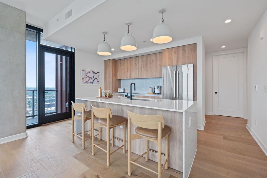 Representative Photo. Kitchen featuring custom Italkraft cabninetry, terrazzo backsplash, waterfall-edge terrazzo countertops, stainless steel Bosch appliances, and pendant lighting above kitchen island