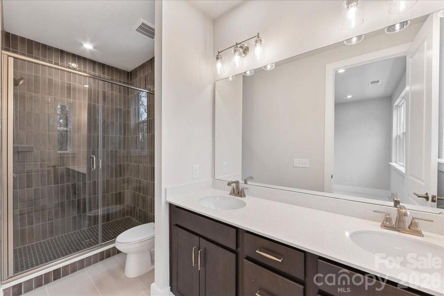 Primary Bathroom with Rich Brown Cabinets and Quartz Countertops