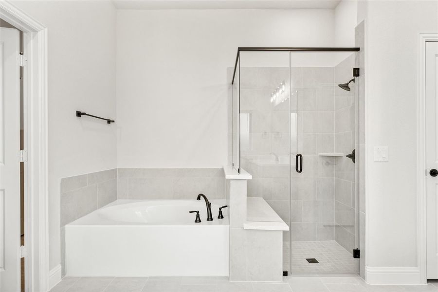 Master bathroom with soaking tub, glass-enclosed shower, gray tile, and matte black fixtures Master bathroom with soaking tub, glass-enclosed shower, gray tile, and matte black fixtures