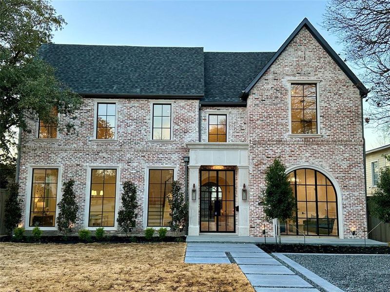 View of front facade with antique brick, cast stone entry and copper gas lanterns