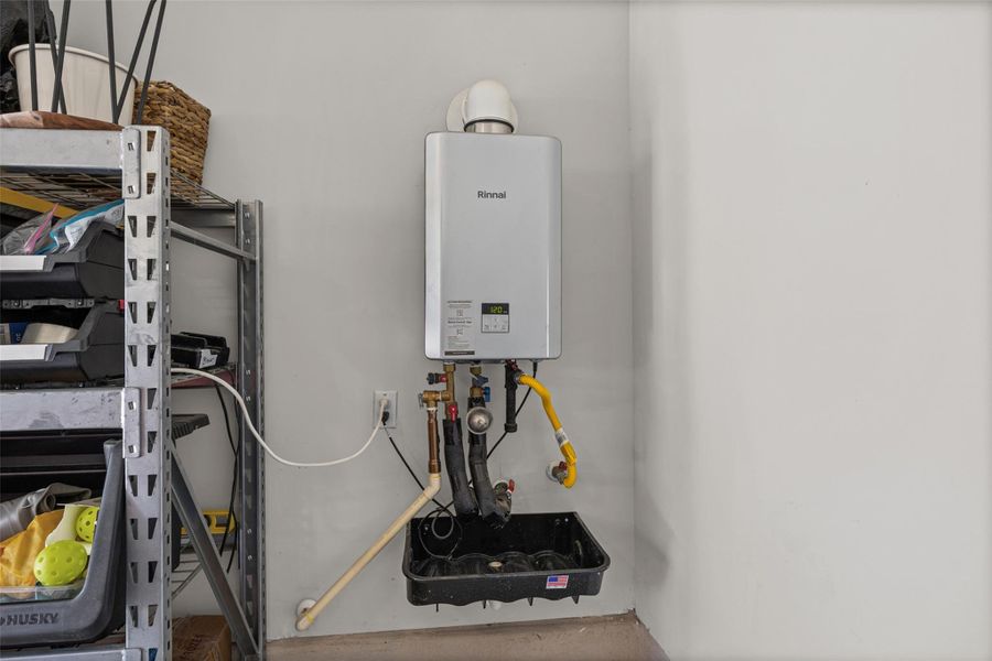 An energy-efficient tankless water heater is mounted on a clean, finished utility wall.