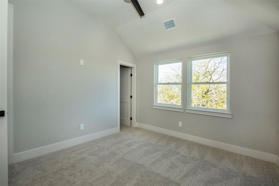 Carpeted empty room with vaulted ceiling