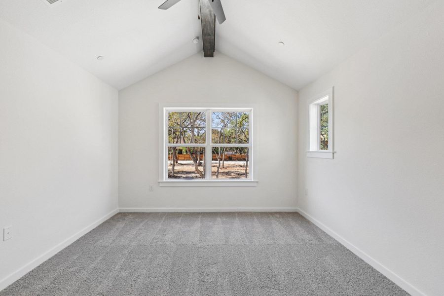 Spare room with light carpet, beam ceiling, and a ceiling fan