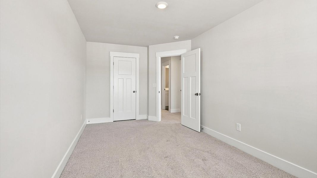 Vibrant and inviting secondary bedroom featuring a walk-in closet and refined finishes by DRB Homes Vibrant and inviting secondary bedroom featuring a walk-in closet and refined finishes by DRB Homes