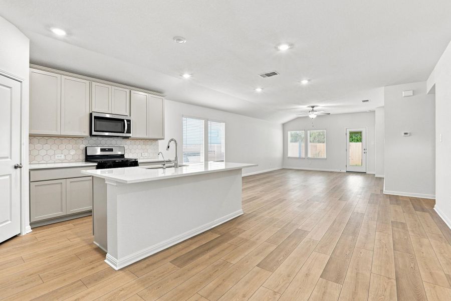 An open floorplan seamlessly connects the contemporary kitchen with a spacious living area.