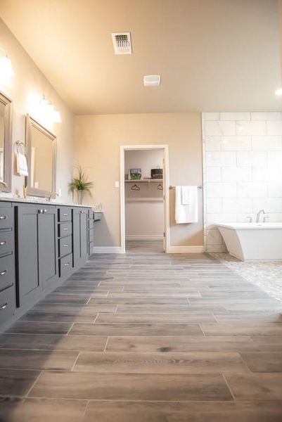 Bathroom with wood finish floors, vanity, and a freestanding tub Bathroom with wood finish floors, vanity, and a freestanding tub