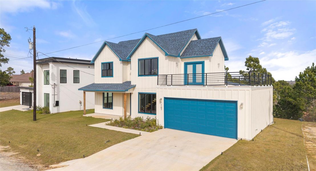 View of front of house with a front lawn, concrete driveway, and roof with shingles
