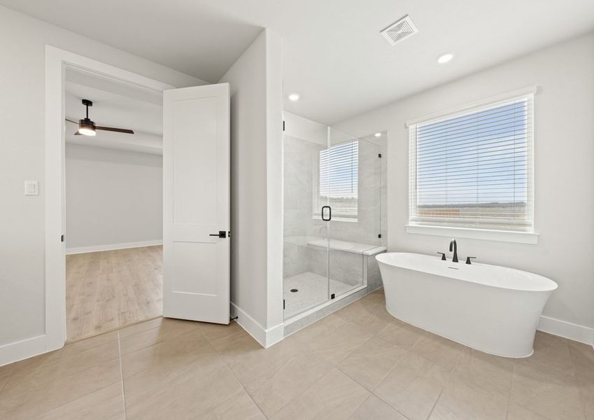 The master bathroom has a garden tub and glass, walk-in shower.