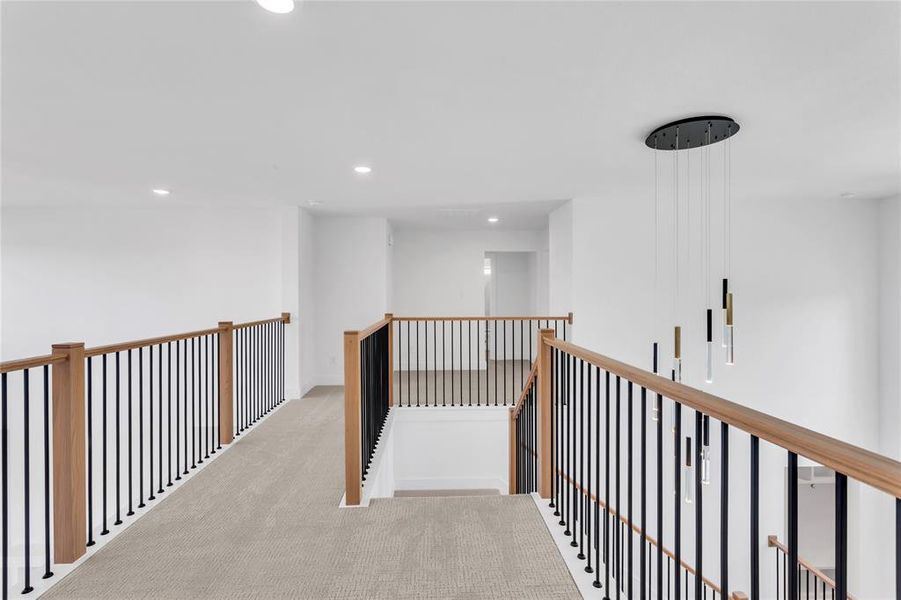 Corridor with carpet floors, recessed lighting, and an upstairs landing