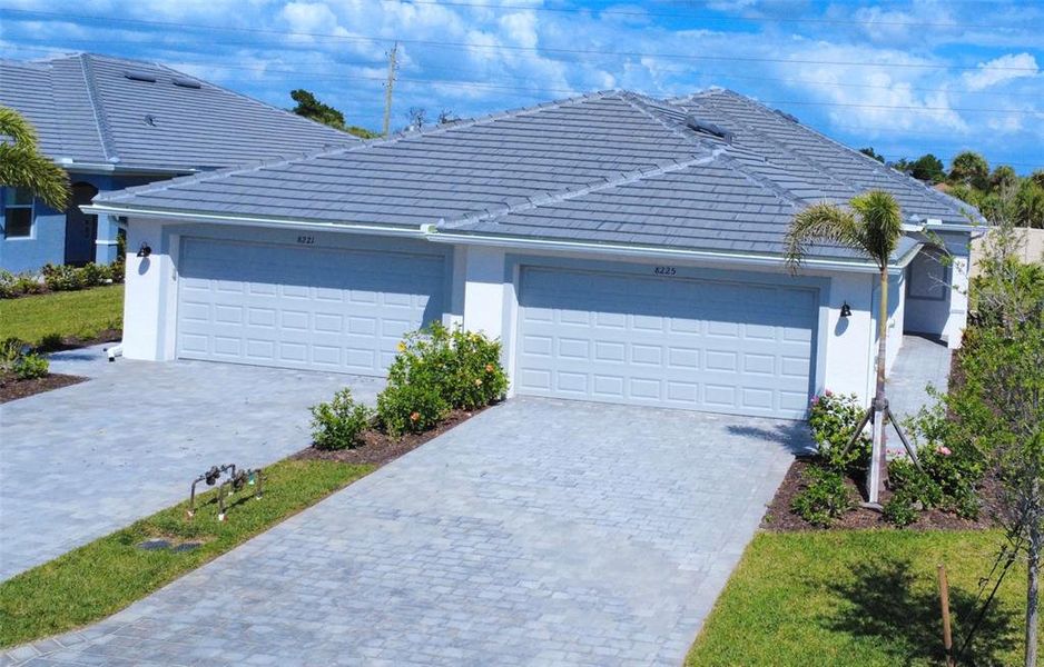 Front exterior of a new home in Palm Lake at Coco Bay, Englewood, FL, highlighting curb appeal (Image 21).