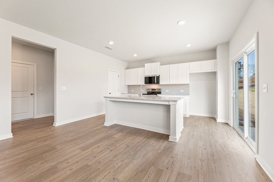 A kitchen with white cabinets.