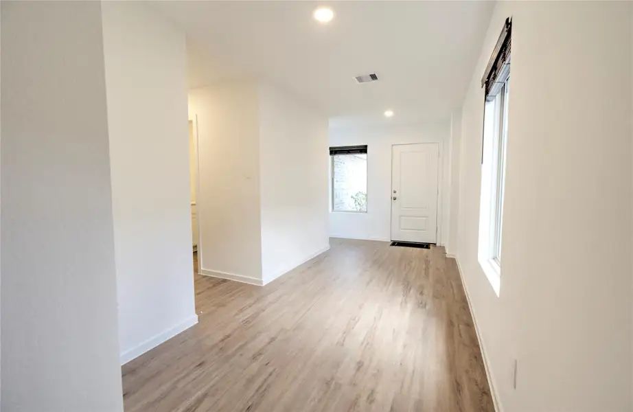 Welcoming foyer with vinyl plank flooring throughout the entry, living space and hallway.  Freshly painted throughout.  Window blinds throughout.