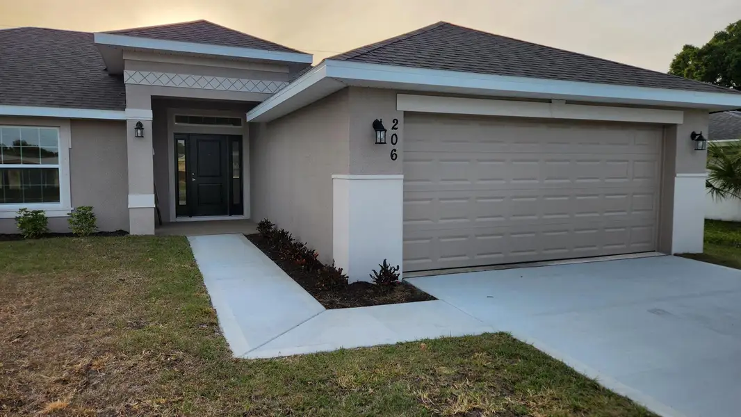 Front exterior of a new home in Gatlin, Port St. Lucie, FL, highlighting curb appeal (Image 14).