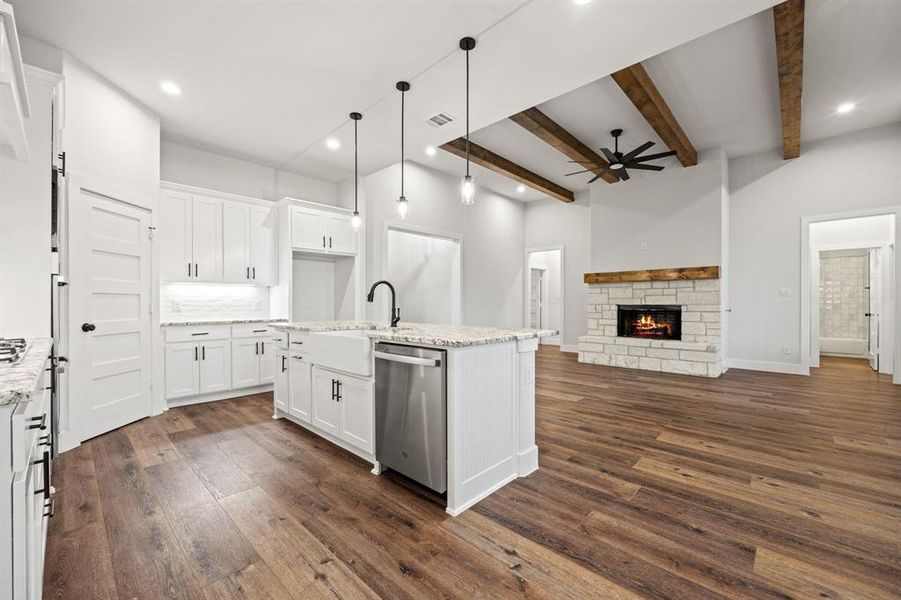 Kitchen featuring white cabinets, open floor plan, dishwasher, and decorative light fixtures