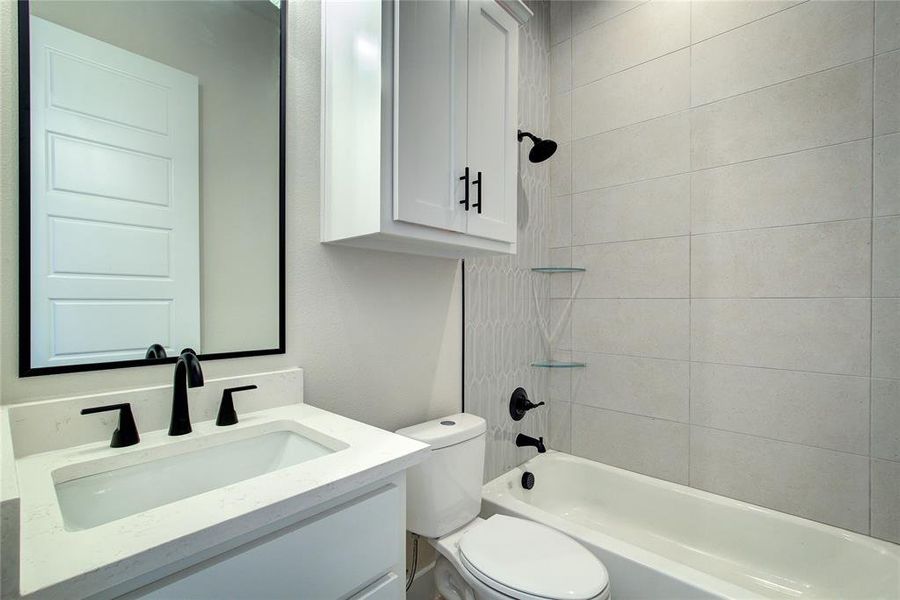 Full bathroom featuring vanity, toilet, and tiled shower / bath combo