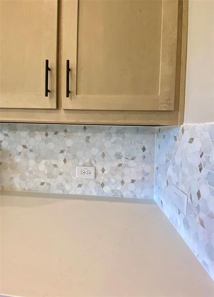 Champagne stained shaker cabinet color is all the rage with elegant hardware to tie in with the oil rubbed bronze fixtures. Matched with Diego Gold Quartz which is white with soft Champagne colored veins running through it. Tied together by decorative mosaic tile backsplash.
