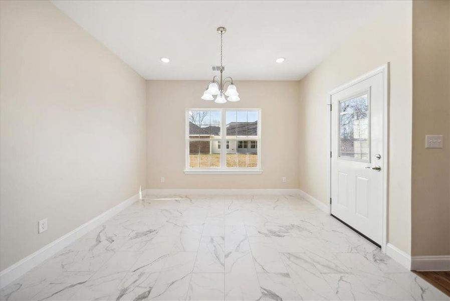 Unfurnished dining area featuring an inviting chandelier