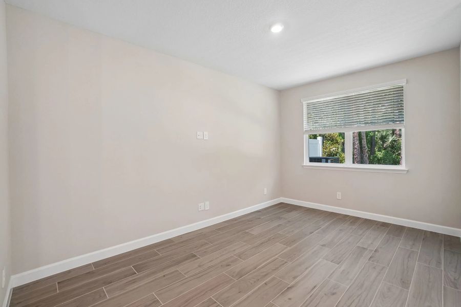 Family room features a double window and a beautiful tree backdrop