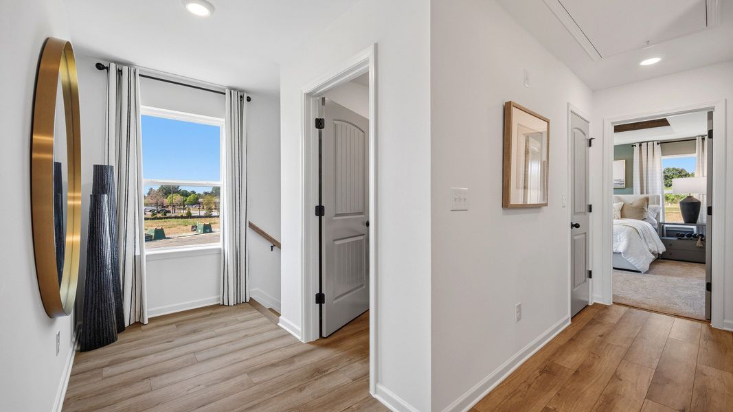Upstairs landing with LVP flooring, open hallway, and natural light in Langley Overlook townhome in Loganville, GA.