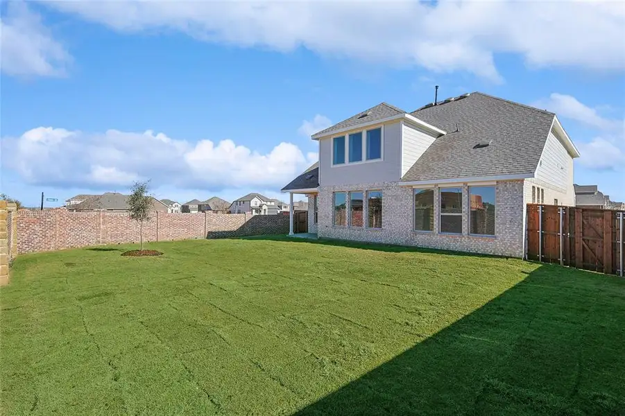Rear view of house featuring brick siding, a fenced backyard, and a shingled roof Rear view of house featuring brick siding, a fenced backyard, and a shingled roof