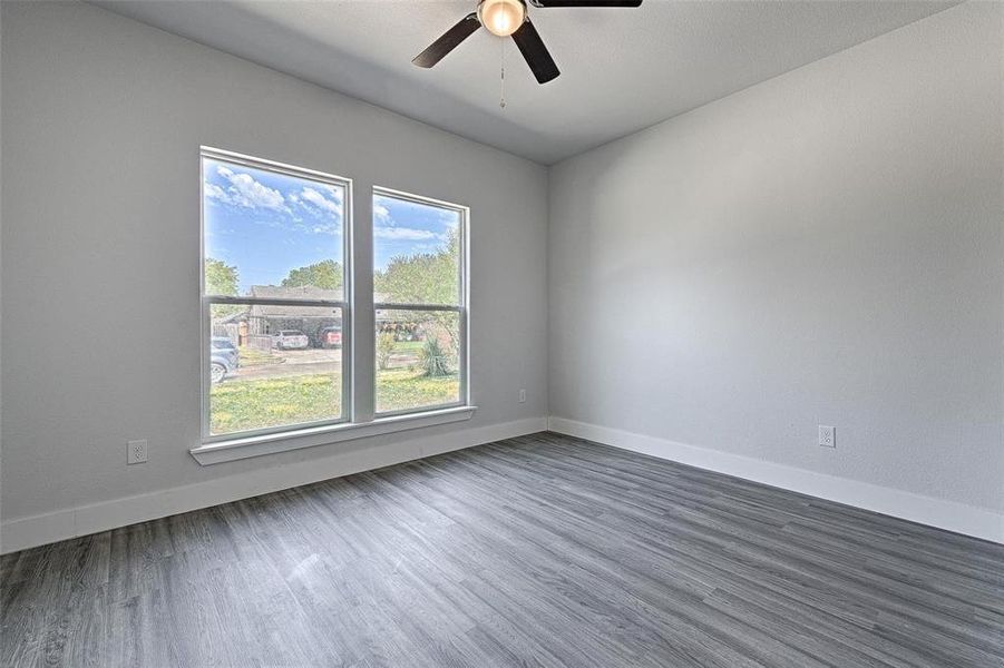 Unfurnished room with ceiling fan and dark hardwood / wood-style flooring