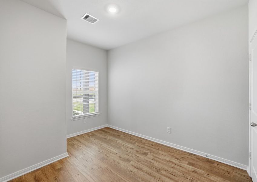 Secondary bedroom featuring a window and wood-look flooring.