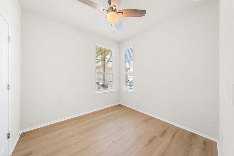 A quiet bedroom showcases light wood flooring and dual windows, offering a peaceful retreat. A quiet bedroom showcases light wood flooring and dual windows, offering a peaceful retreat.