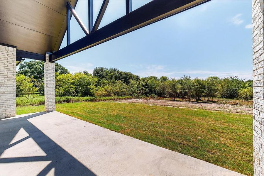 View of grassy yard featuring a patio