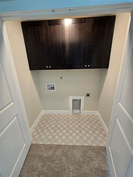 Washroom with hookup for a washing machine, hookup for an electric dryer, hookup for a gas dryer, cabinet space, and baseboards