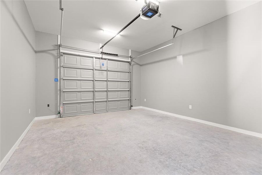 Garage with a garage door opener and baseboards