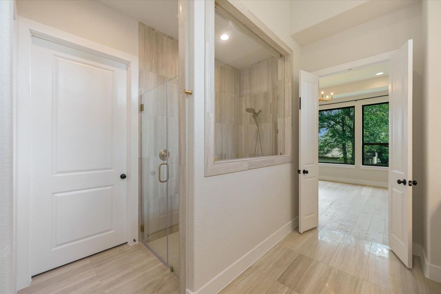 A private shower area with tile flooring provides a refreshing escape, connecting to an adjacent room through French doors.