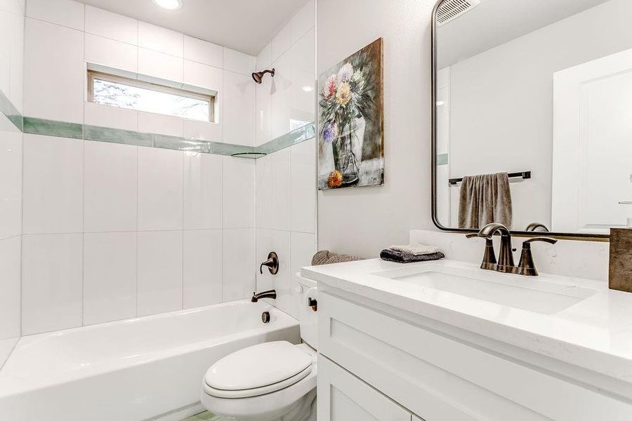 Full bathroom with vanity, toilet, and tiled shower / bath