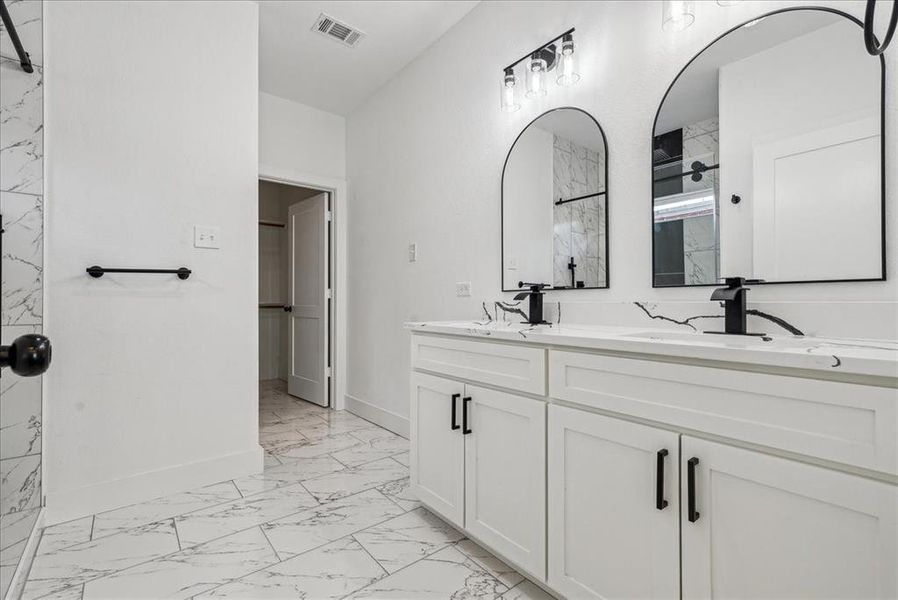 Primary bathroom featuring double vanities and tile patterned floors