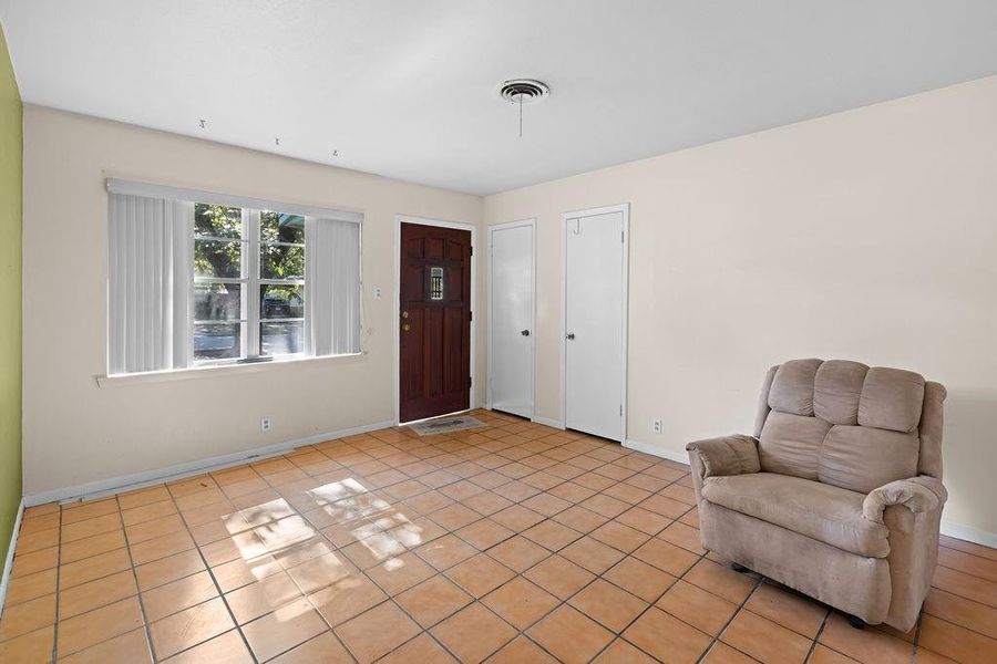 Foyer entrance with light tile patterned floors and baseboards