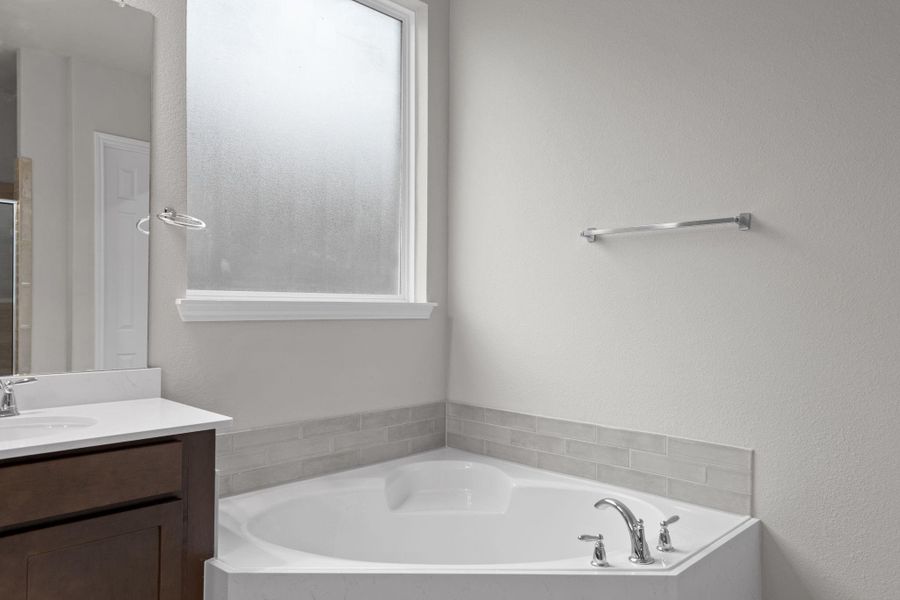 This additional view of your primary bathroom features tile flooring, fresh paint, walk-in shower, a separate garden tub, and a large walk-in closet.