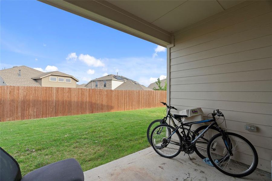 Covered patio with a concrete surface, siding exterior, and a manicured lawn